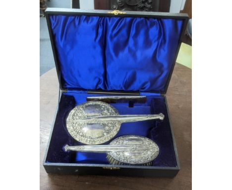 Charles S Green and Co three piece silver dressing table set compromising of hand mirror, hand brush and comb having floral e