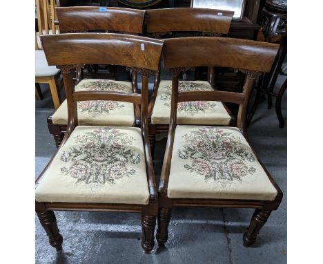 A set of four William IV mahogany bar back dining chairs, tapestry upholstered drop in seats, on turned and carved front legs
