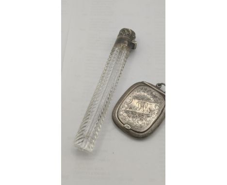 A Victorian lay down perfume bottle having a silver floral embossed lid and engraved initials on a crystal cut glass bottle, 