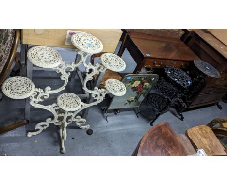 A white painted cast iron plant stand, a black finished pedestal cast iron plant stand and a black finished three tier pot st