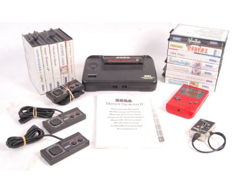 An original vintage Sega Master System video games computer console having A/C adaptor, aerial, 3x control pads, 12x games to