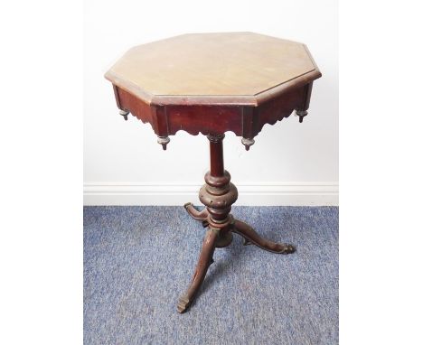 A mid-19th century octagonal mahogany occasional table; wavy frieze, inverted finials, turned stem and raised on tripod base