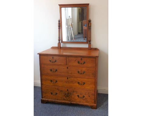 A late 19th century pitch-pine dressing chest; the rectangular mirror above an arrangement of two half-width and three full-w