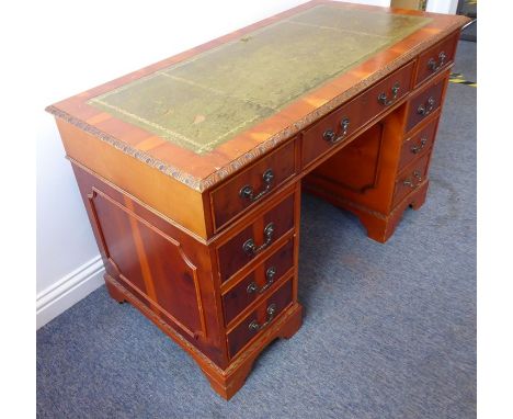 A reproduction Georgian-style yew-wood pedestal desk; the gilt-tooled green-leather inset moulded top above an arrangement of
