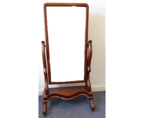 A mid-19th century mahogany cheval mirror, the mirror plate with cushion-moulded frame