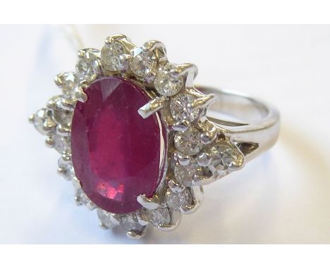 An 18-carat white-gold ruby and diamond cluster ring; ring size N ((total weight 7.71g) (The cost of UK postage via Royal Mai