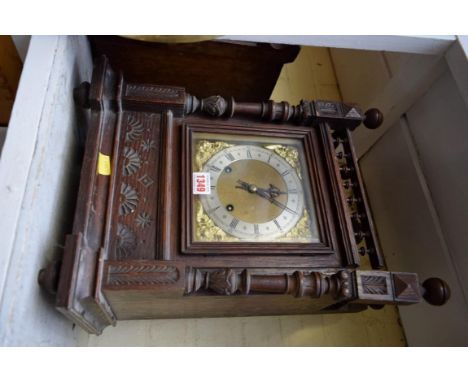 A late 19th century/early 20th century carved oak mantel clock, 48cm high. 
