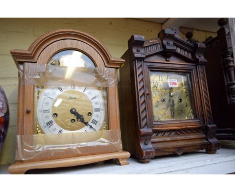 An antique walnut mantel clock; together with a reproduction oak example. 