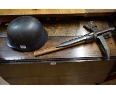 A German Third Reich Luftschutz combat helmet; together with a K98 bayonet and escape axe, in leather sheath.