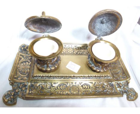 BRASS INKWELL. Victorian brass double ink well and pen rest with ceramic inkwells, L: 20 cm 