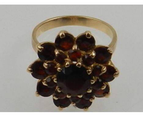A 9 carat yellow gold and garnet floral cluster ring.