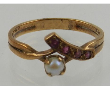 A 9 carat yellow gold, ruby, and pearl crossover ring, set four round cut rubies and a pearl. 