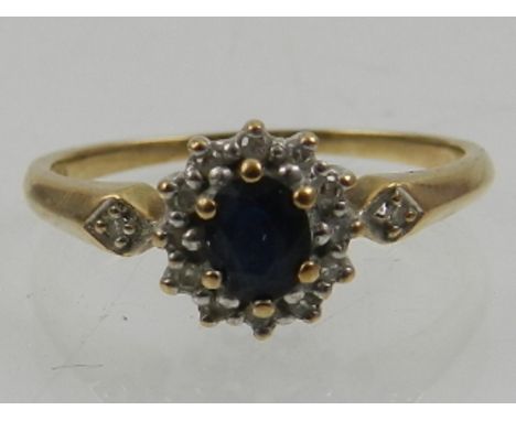 A 9 carat yellow gold, diamond, and sapphire cluster ring. 