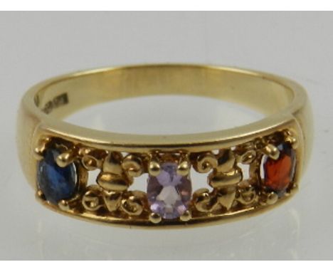 A 9 carat yellow gold, garnet, amethyst and sapphire ring, the three stones set in an openwork mount. 