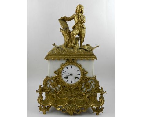 An early 20th century French white marble and gilt mounted mantel clock, the surmount modelled as a boy standing beside a tre