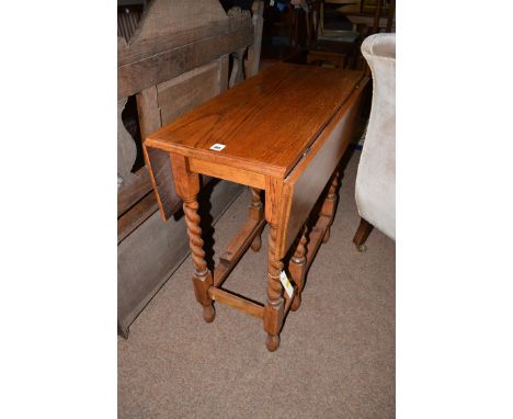 An early 20th Century oak drop leaf table, the barley twist legs with gate action.