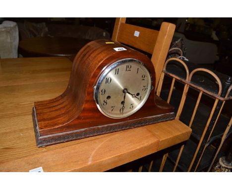 A stained wood cased mantel clock with silvered arabic dial.