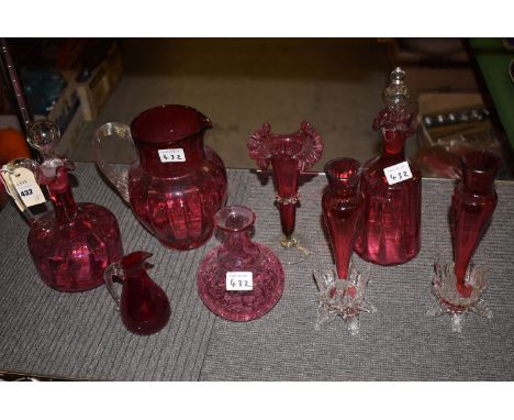 Cranberry glass ware to include: a claret jug; a decanter; a pair of spill vases; a large jug; etc.  (8)