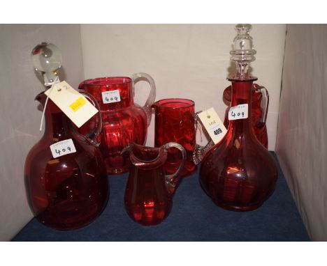 Cranberry glass, to include: a decanter; a claret jug; and four jugs, various.  (6)