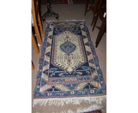 A Persian rug, decorated central medallion on ivory ground.