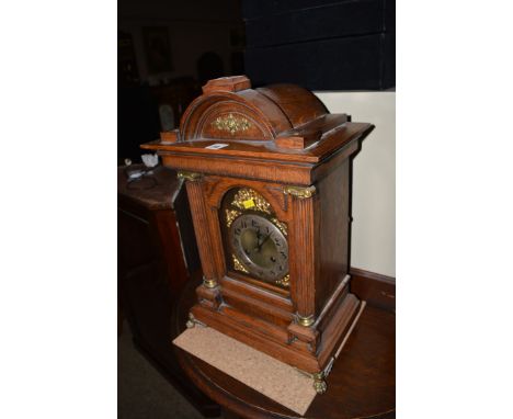 An oak cased mantel clock, the Art Nouveau style arabic silvered dial within brass face.