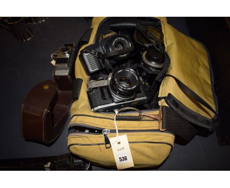 Cameras and accessories to include: a Cannon T 50; Canon AE-1; a Bell & Howell Auto Set II; a Kodak Instamatic 233; together 