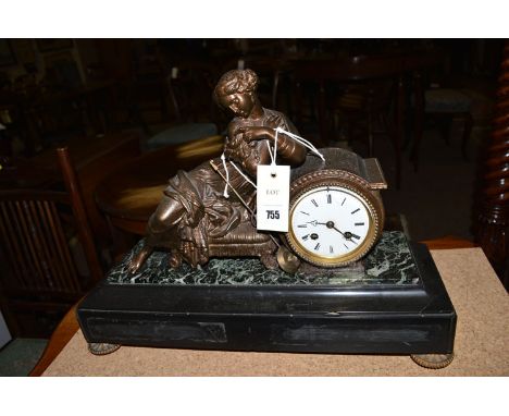 A late 19th Century mantel clock, the patinated spelter top depicting a reclining female figure on a stool by the white ename