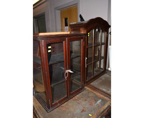 A mahogany hanging shelf unit with glazed panel door enclosing shelves; together with another.