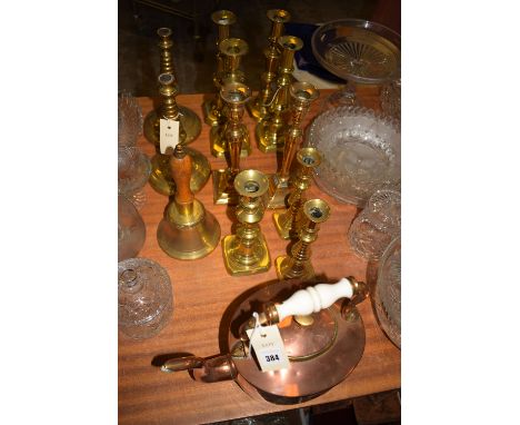 A copper kettle; a brass hand bell; five pairs of brass candlesticks; and another candlestick.