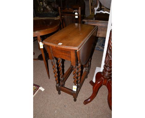 An early 20th Century oak drop leaf table, the barley twist legs with gate action.