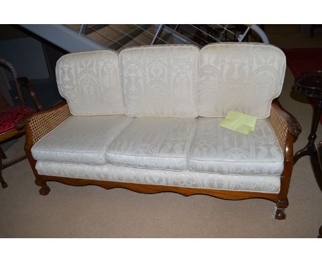 A Victorian style mahogany bergere sofa, the triple panel back and arms with modern caning, claw pattern arm finials, raised 