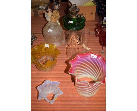 An early 19th Century oil lamp with green reservoir; together with four glass lamp shades, one with fluted cranberry top thro