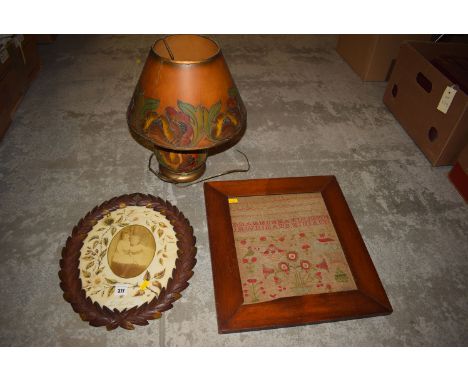 A 19th Century framed sampler; 1920's table lamp; together with a 19th Century carved wood photo frame containing a photograp