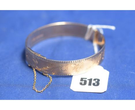 A 9ct. yellow gold bangle, by Redfern Jewellery Co., Birmingham 1974, with floral engraved decoration, 27grms.