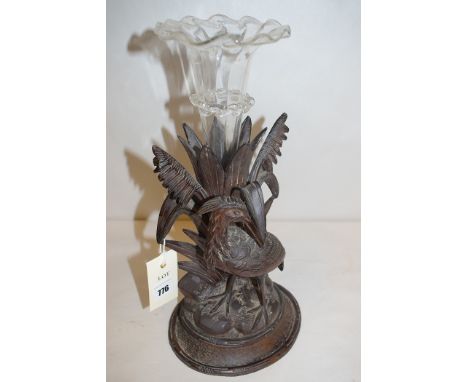 An ornately carved wooden epergne stand in the form of a stork standing in front of reeds with a trumpet shaped epergne vase.