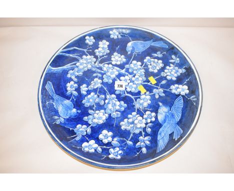 A large ceramic wall plate with underglazed blue decoration on cream coloured ground inscribed on the reverse in script "Doul