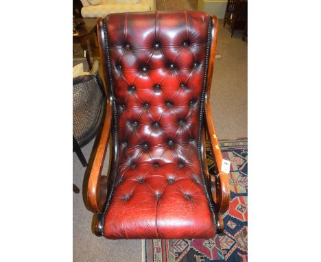 A 20th Century mahogany open armchair, the button back and seat upholstered in red leather.