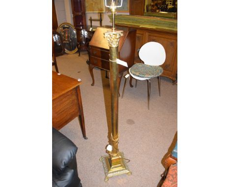 A 20th Century brass standard lamp, with corinthian style column, raised on a square base terminating in paw feet.