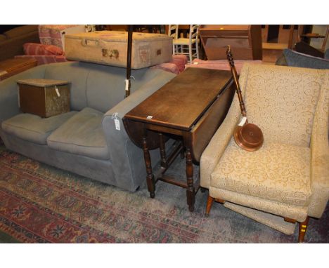 A modern two-seater sofa bed upholstered in green material plus a 20th Century armchair upholstered in gold coloured patterne