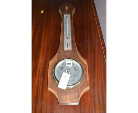 A modern barometer by Russell, in oak case.