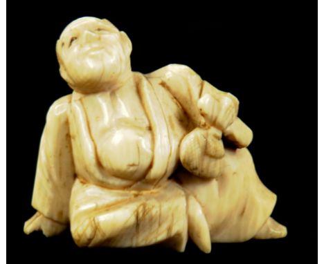 A JAPANESE IVORY NETSUKE OF A SEATED MAN, LATE 19TH/EARLY 20TH CENTURY