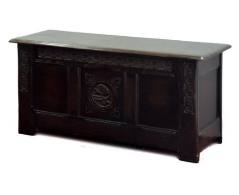 A CARVED OAK CHEST WITH THREE PANEL FRONT