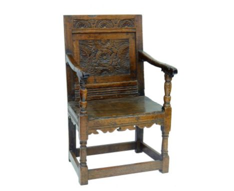 A CHARLES II OAK PANEL BACK ARMCHAIR CARVED WITH LUNETTES AND GUILLOCHE