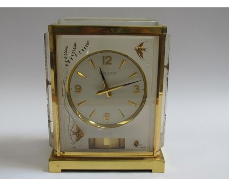 A Jaeger LeCoultre ''Marina'' Atmos clock with decorative fish design internal panels (some with crazing), gilt brass framed 