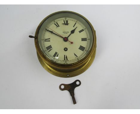 An early to mid 20th Century Smiths Astral brass cased ships clock with key, Roman dial with red seconds hand, 11cm high