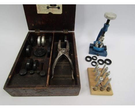 A collection of watchmaker's tools including mainspring winders, UB crystal inserting tool with dies, case back remover with 