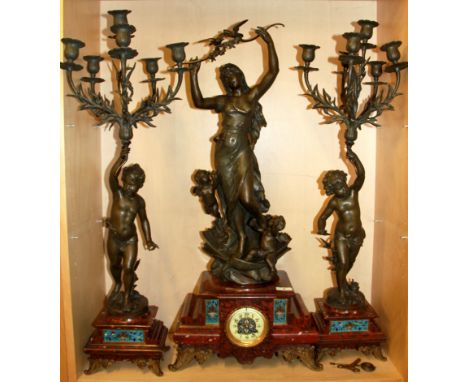 A large French marble and spelter enamelled three piece clock garniture, signed Ferrand,  (some candlestick branches repaired