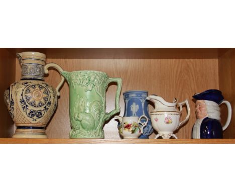 A group of six ceramic jugs along with a collection of Victorian porcelain chamber sticks and three candlesticks.