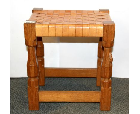 A carved oak and leather Mouseman (Robert Thompson of Kilburn) stool, H. 38cm.