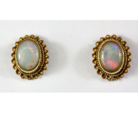 A pair of 9ct yellow gold opal set stud earrings, L. 1.1cm.